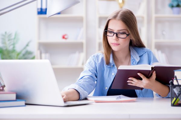 Young teenage female student preparing for exams at home